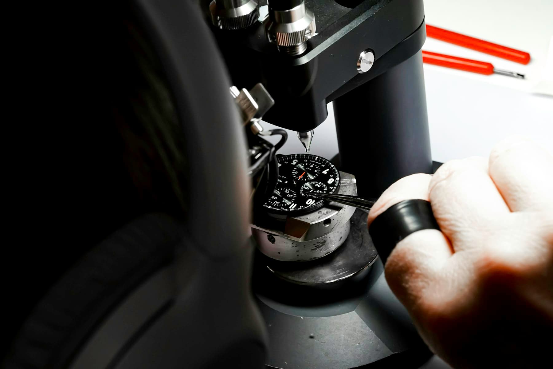 Watchmaker inspecting a movement through a microscope