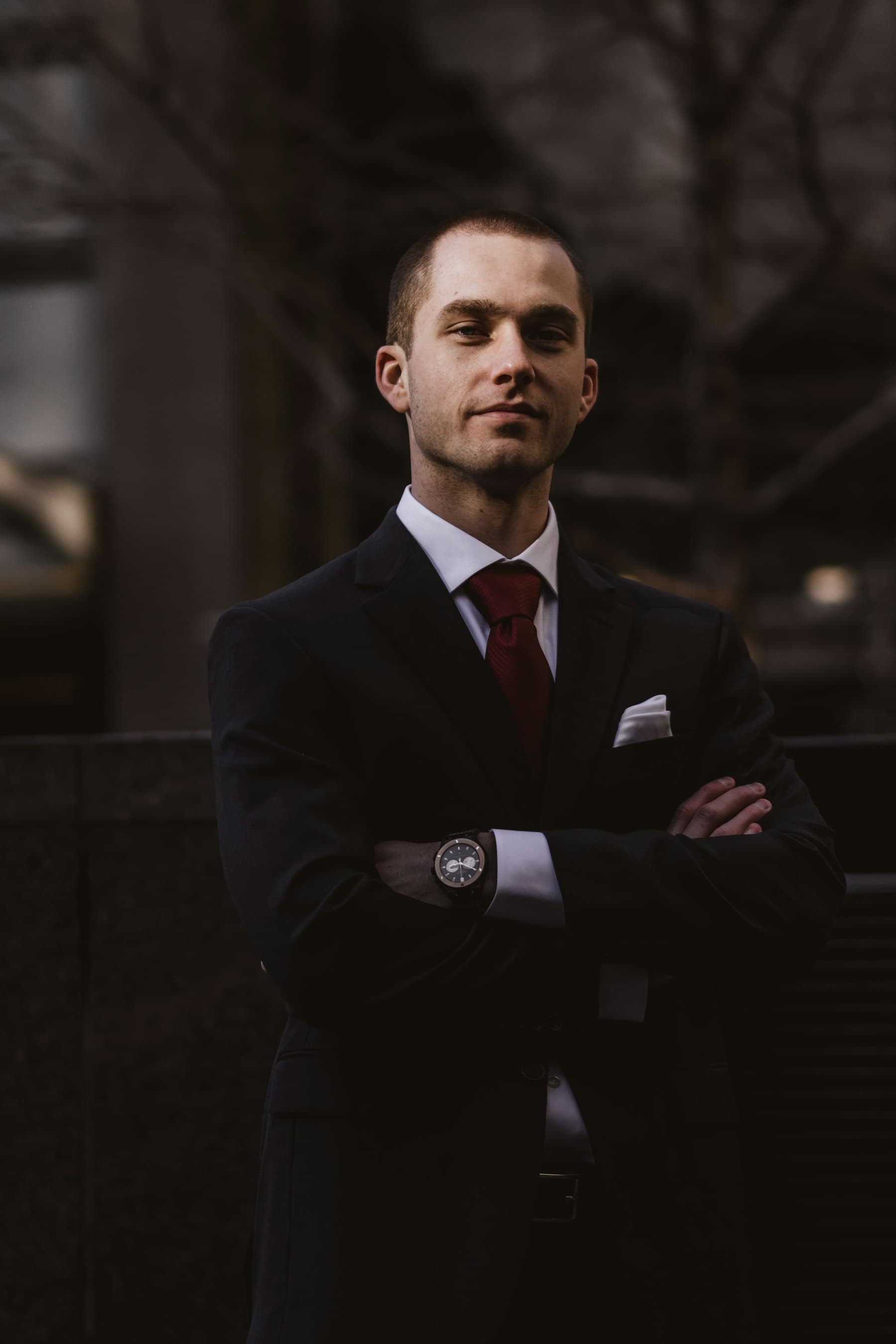 A man in a dark suit, photographed in low light